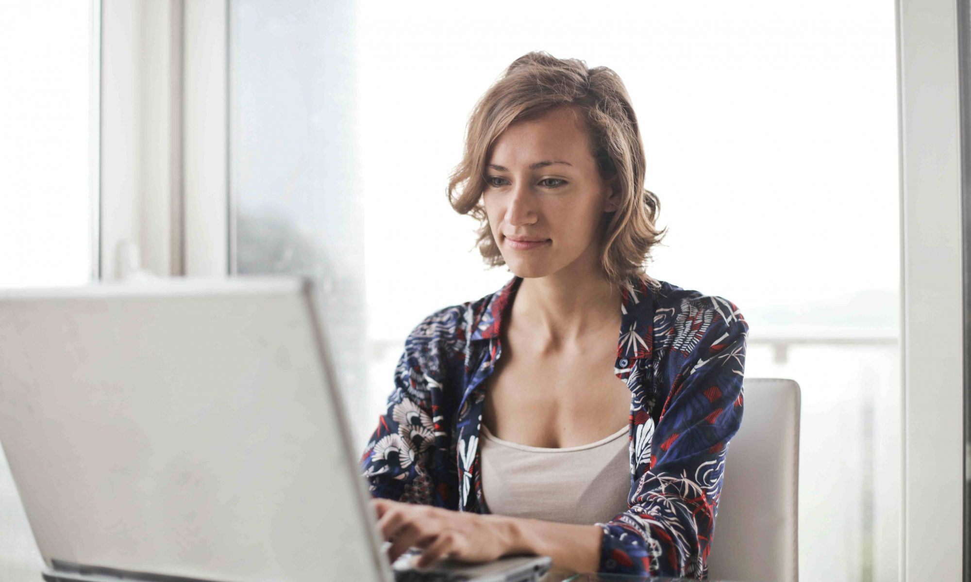 Mujer usando computadora por obligaciones de obra social